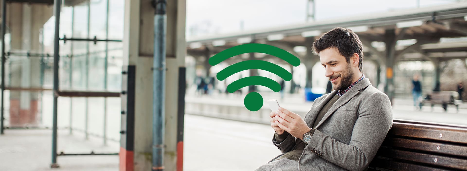 Mann am Handy am Bahnhof