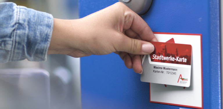 Parkticket wird vor dem Leserger&auml;t gehalten