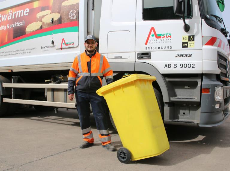 Foto Mitarbeiter der AVG mit gelber Tonne