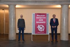  Dr. Reinhard Böhlau, „Internationale Ärzte zur Verhütung des Atomkriegs – Ärzte in sozialer Verantwortung (IPPNW)“ und Oberbürgermeister Jürgen Herzing vor der Fahne im Lichthof des Rathauses