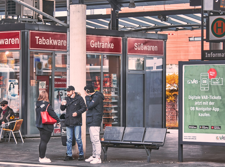 3 Menschen unterhalten sich am Bahnhof