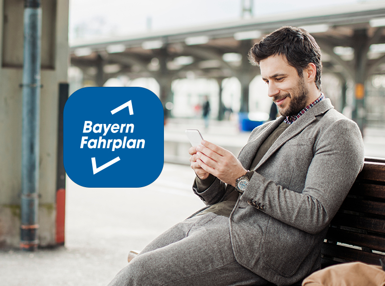 Mann sitzt am Bahnhof