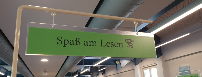 Grüne Fahne am Buchregal mit dem Text "Spaß am Lesen"