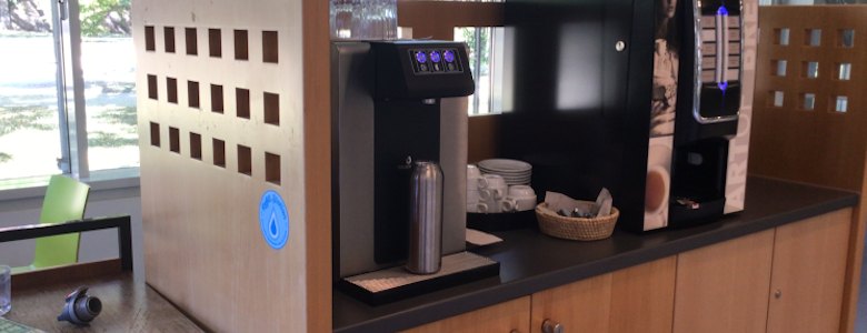 Trinkwasserspender neben Kaffeemaschine