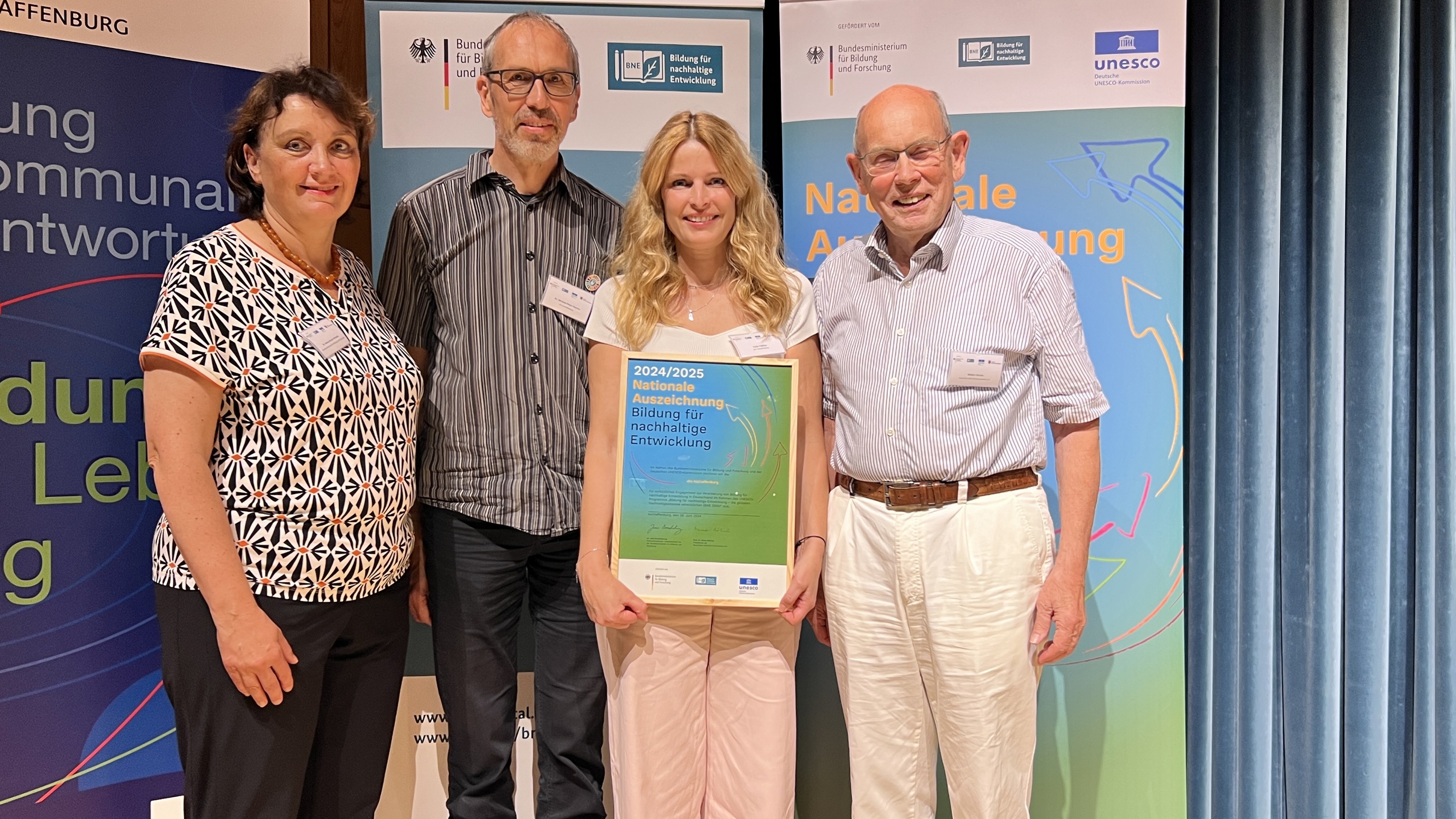 (v.l.n.r.) Dr. Andrea Ruyter-Petznek (BMBF), Dr. Michael Peter Hoecke (vhs), Katja Fröhlich (vhs) und Walter Hirche (DUK) am 28. Juni 2024 bei der Verleihung der „Nationalen Auszeichnung Bildung für nachhaltige Entwicklung“ in der Stadthalle.