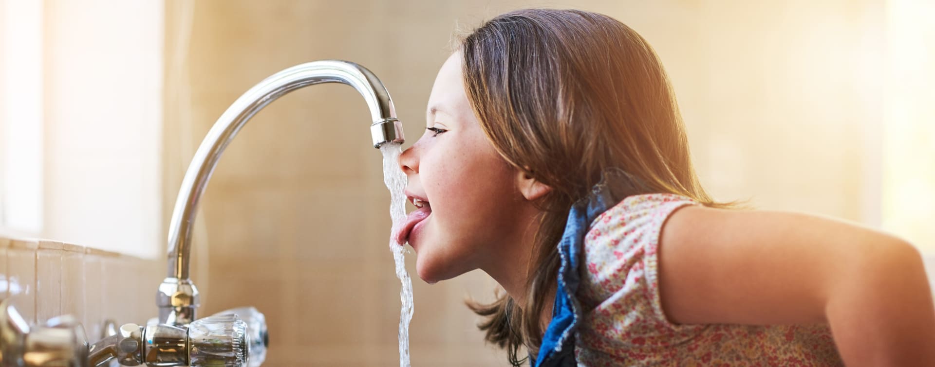 M&auml;dchen trinkt Wasser aus Wasserhahn
