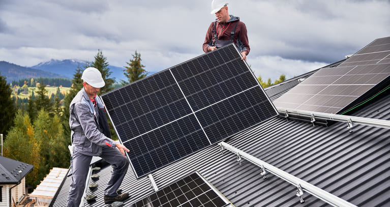 Installateure installieren Solarpanele auf dem Dach.