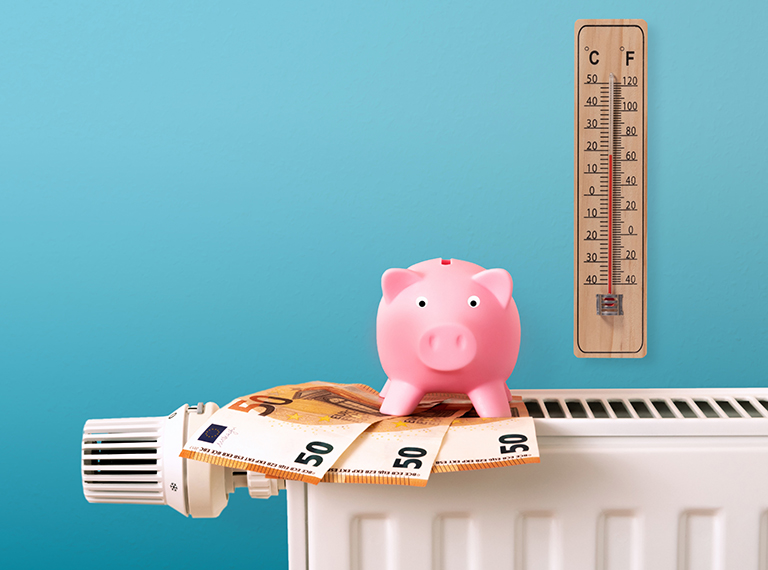 Heizung mit Geld, Sparschwein und Thermometer