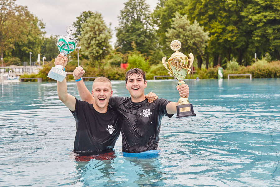 2 Menschen mit Pokalen im Wasser
