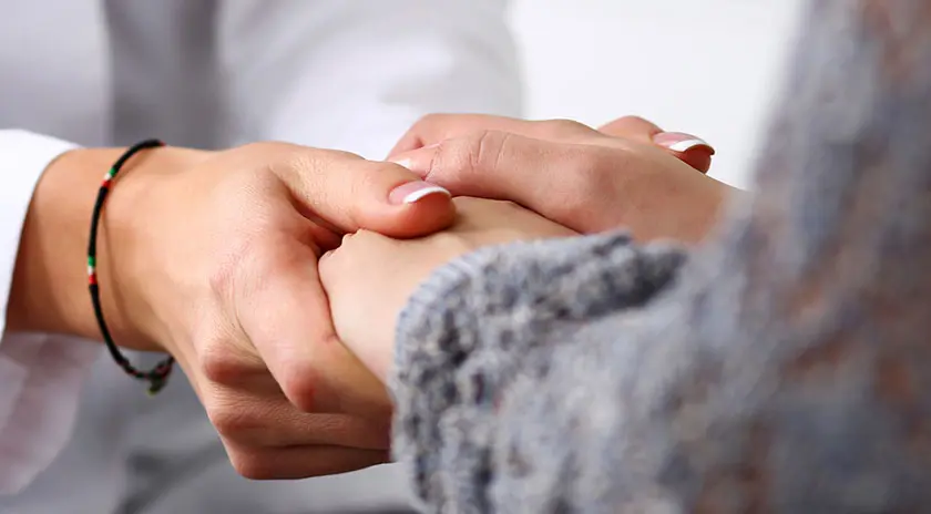 Zwei Personen halten sich gegenseitig die Hände