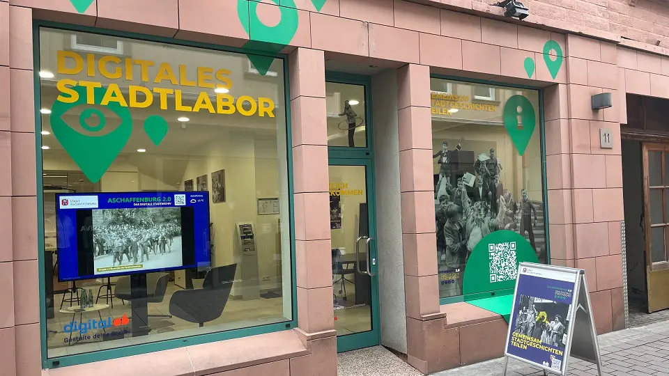 Der Digitalladen von Außen mit Kundenstopper vor dem Schaufesnter.