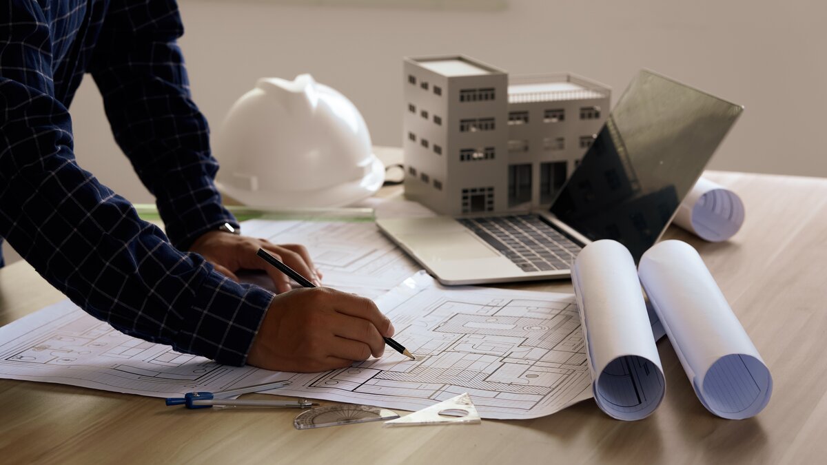 Mensch arbeitet an Bauplan