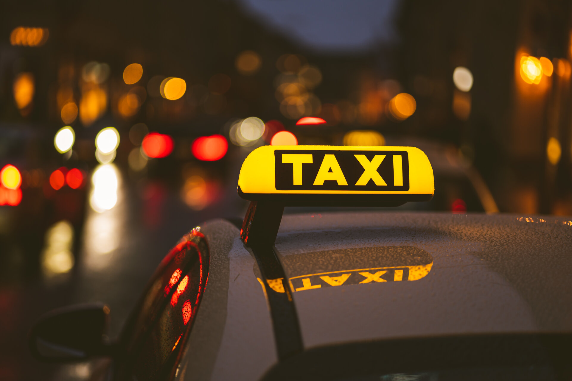 Nahaufnahme Taxischild auf einem Taxi bei Nacht