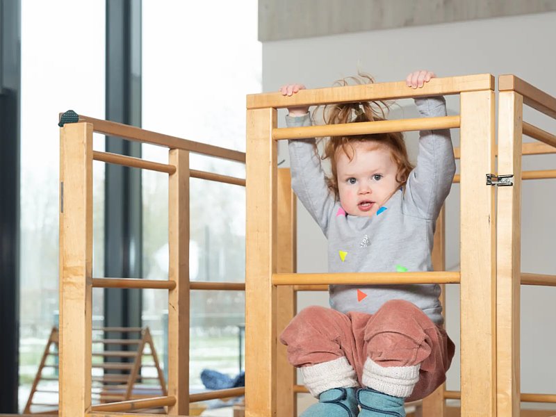 Kind turnt auf Holzgerüst