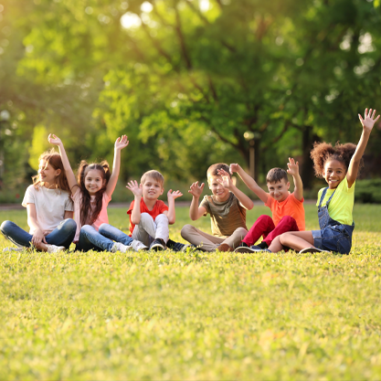 Fröhliche Kinder sitzen auf einer Wiese