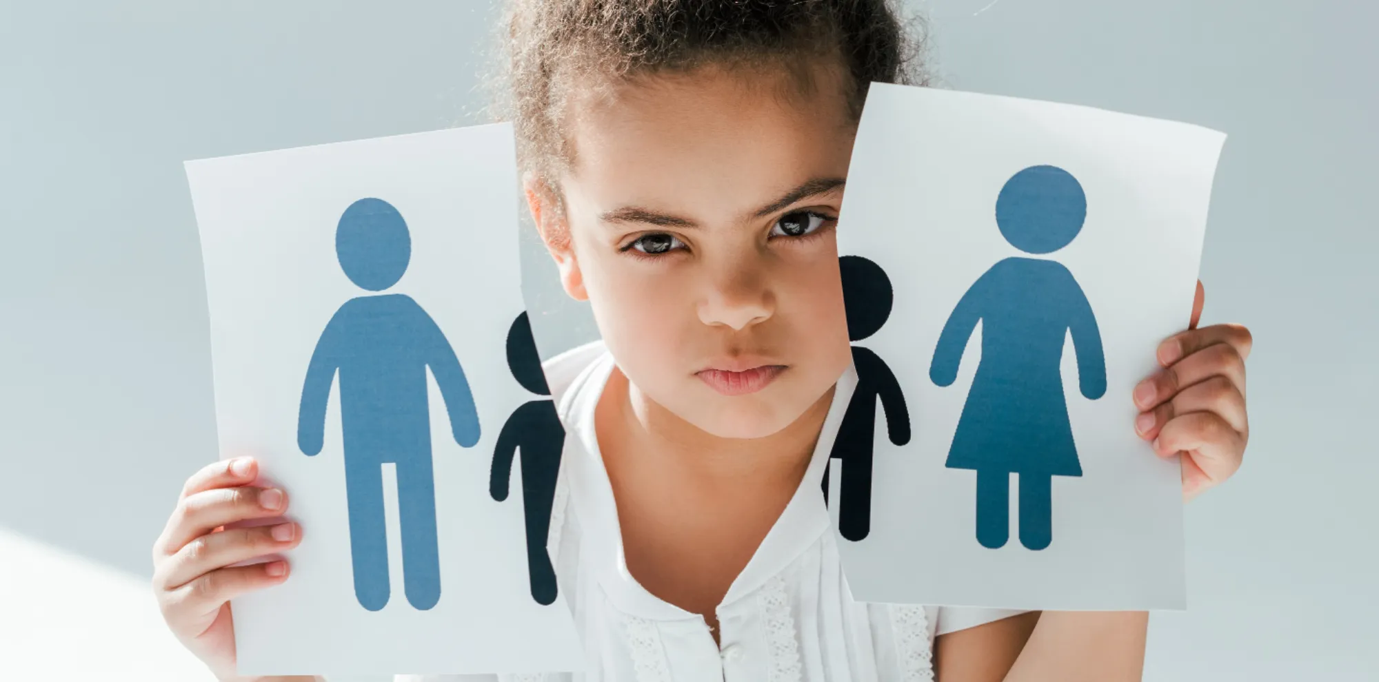 Kind hält zerrissene Familienbilder, Symbol für Trennung/Scheidung. ISUV-Thema Familie, Homepage.