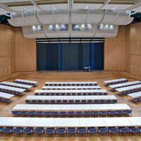Kirchner Saal der Stadthalle am Schloss mit Bühne und parlamentarischer Bestuhlung.