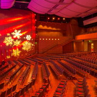Kirchner Saal der Stadthalle am Schloss mit Reihenbestuhlung und weihnachtlicher Lichtprojektion von Schneeflocken.