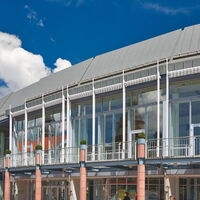 Außenansicht der Stadthalle am Schloss in Aschaffenburg bei Tag mit moderner Glasfassade.