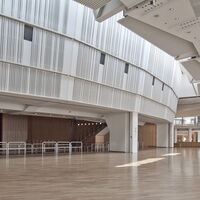 Weitläufiges, lichtdurchflutetes Foyer des Kirchner Saals in der Stadthalle am Schloss mit Blick auf mobile Tribüne und Eingangsbereich.